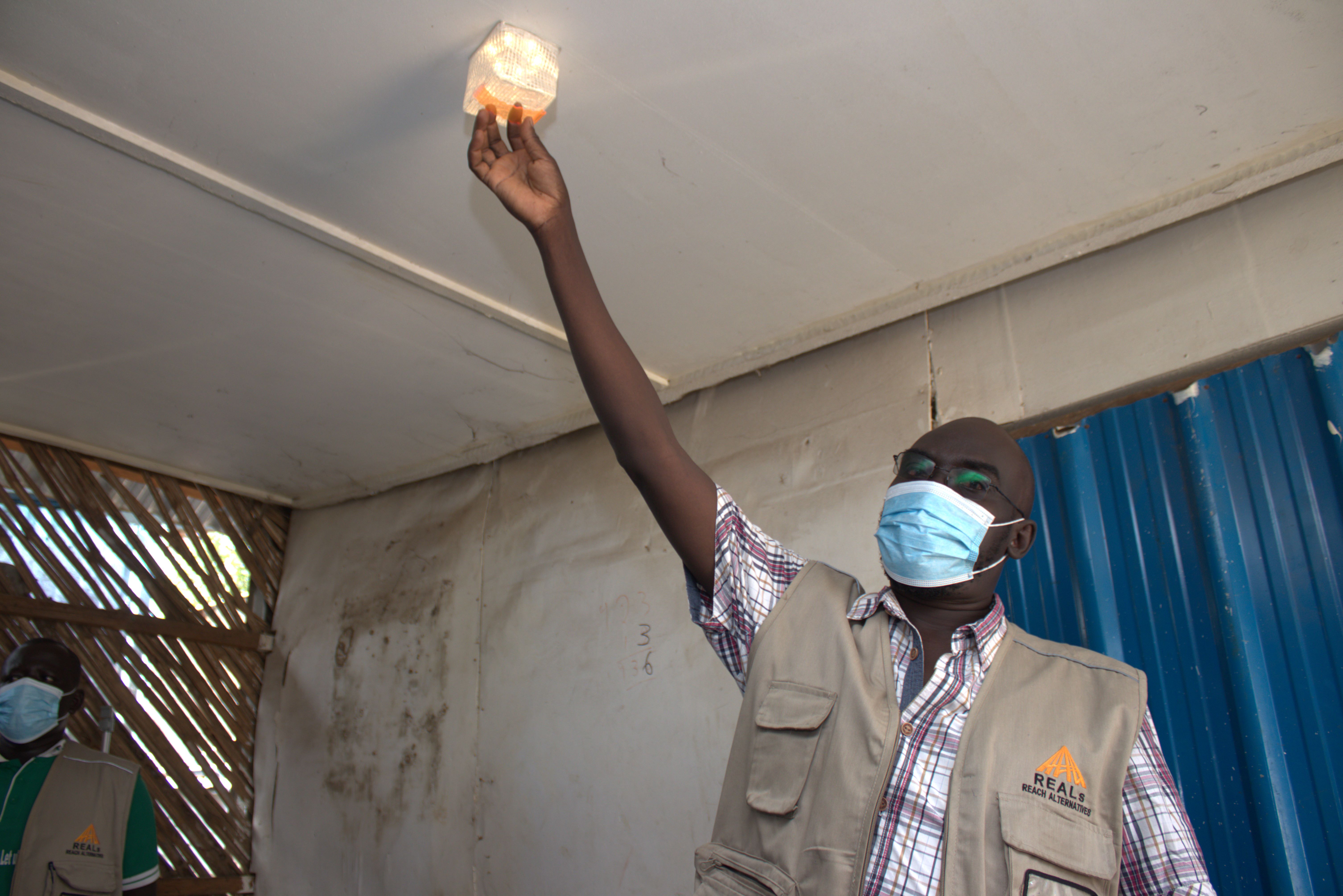 配布会場でCARRY THE SUNの使い方を説明するREALs南スーダン・スタッフ